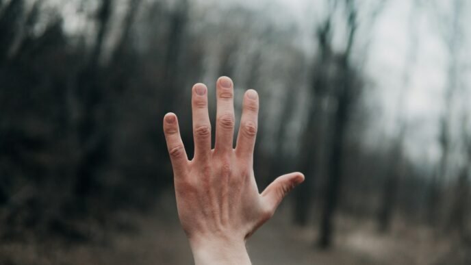 shallow focus photography of person's left hand outside